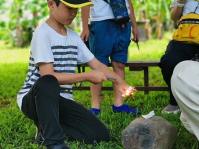 火起こし体験をする少年